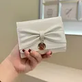 Cartera chic de cuero sintético blanco crema con lazo y colgante dorado - Blanco