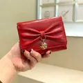 Cartera de charol rojo brillante para mujer con lazo grande y colgante metálico circular - Rojo
