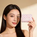 Close-up of pink bow wallet with sweet girl lettering and quilted pattern held by model - Light Pink