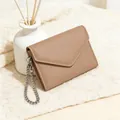 Detail of khaki pebbled leather envelope wallet with silver chain on knit fabric - Khaki