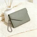 Detail of sage green lychee textured leather wallet with silver chain on knit fabric - Matcha Green