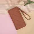 Cartera larga acolchada en color marrón oscuro de cuero con correa de muñeca y cremallera - Marrón