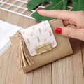 Nahaufnahme einer Mini-Geldbörse aus PU-Leder mit Blattprint, Gold-Schnalle und Quaste - Khaki