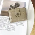 Detail of vintage bi-fold wallet with olive green leather texture and daisy buckle - Gray