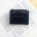 Short black women's wallet with star-shaped quilting and golden zipper detail - Black