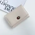 Portafoglio beige minimalista da donna con chiusura a rotazione dorata e trama in pelle litchi - Bianco