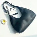 Minimalist black crescent shoulder bag in matte faux leather with top zipper closure - Black