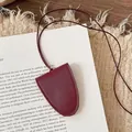 Close-up of wine red leather glasses holder with stitching detail on a vintage book - Magnetic Sunglasses Clip / Red