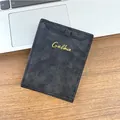 Portefeuille mince en cuir noir mat pour homme avec logo doré sur un bureau pro - Noir