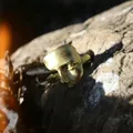 Bague masque artistique dorée avec finition mate sur fond roche naturelle - Or