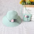 Detail von hellgrünem Strohhut und passender Tasche mit floralen Bandakzenten - Grün