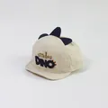 Detail der Baby Dinosaurier Kappe mit 3D-Flossen und Dino-Stickerei auf beiger Baumwolle - Beige