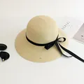 Beige straw sun hat with black ribbon bow and wide brim shown with lifestyle props - M Adult 58cm / Beige-Black Ribbon