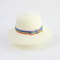 Detail of straw hat featuring rainbow ribbon and bow decoration on cream woven material - Milk White - Colorful Ribbon Bow