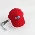 Detail van rode katoenen kinderpet met blauwe patch en wit geborduurde letters - Verstelbare Kindermaat / Rood