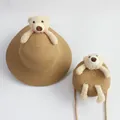 Detailed view of straw sun hat and matching small round bag with plush bear ornament - Wide Brim Set / Khaki