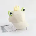 Détail de la casquette grenouille beige avec couronne jaune et yeux verts sur fond blanc - Taille Unique(Réglable) / Beige