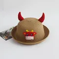 Detailopname van een strooien kinderhoed met rode hoorns en een koeienembleem - 52cm / Khaki-Geluksstier