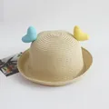 Detailed texture of beige straw sun hat featuring blue and yellow knitted heart accents - Yellow Blue Hearts / Beige / One Size