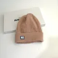 Dusty pink cable knit beanie with VE. logo patch on a white gift box backdrop - M (56-58cm) / Camel