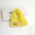 Berretto invernale giallo in maglia a trecce con patch VE su sfondo bianco - Taglia unica / Giallo