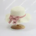 Detail of hand-woven straw hat featuring a pink ribbon bow and 'Hand made' leather tag - S Kids Size / Lotus Leaf Single Hat / Cream