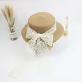 Detailed top view of a flat top straw hat featuring a cream lace ribbon bow and tassels - S Kids 52cm / Khaki