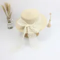 Detail of cream straw hat featuring wide floral lace ribbon and oversized bow decoration - S Kids 52cm / Beige