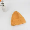 Dettaglio del berretto in maglia spessa giallo zenzero con risvolto a costine - Taglia unica / Arancione