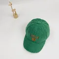 Detailaufnahme der grünen Fleece-Baseballkappe mit gesticktem Smiley und SMILE-Schriftzug - S / Grün