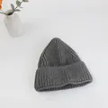 Dettaglio del berretto in maglia grigio scuro con trama a coste e morbida lana calda - Taglia unica / Grigio