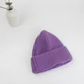 Dettaglio del berretto in maglia viola spessa che mostra la trama a coste della lana - Taglia unica / Viola