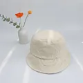 Dettaglio del cappello a secchiello beige in cotone con ricamo a frange e volto sorridente - S(50cm) / Bianco avorio