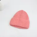 Gros plan détaillé du bonnet en maille rose épaisse avec revers classique et texture - Rose