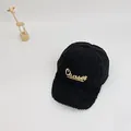 Detail of black faux fur baseball cap featuring gold Chaser script embroidery text - Black