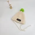 Close-up of baby knit hat with large green pompom and embroidered patch details - S (48-52cm) / Beige