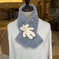 Detail of grey plush scarf with a cute cream bear decoration on white knit sweater - Gray