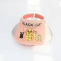 Detail view of the pink sun hat featuring cute cartoon cats and black cat lettering print - S Children (48-53cm) / Orange