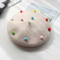 Beige Kinder-Baskenmütze aus Wolle mit bunten Bommeln und weicher Filzoberfläche - S Kinder (48-52cm) / Milchweiß