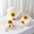 Detail of straw hat and matching bags set with bright sunflowers and pompom tassels - Round Crossbody Bag / 15x5.5cm / Cream