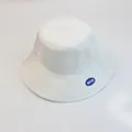 Primer plano de un sombrero de pescador blanco con un parche azul de NEAS - S Niños / Blanco