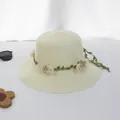 Detailansicht eines cremefarbenen Strohhuts mit zartem Blumenkranz und Kristallbesatz - Seidennetzblume Breite Krempe - Milchweiß