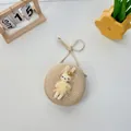 Runde Stroh-Umhängetasche mit süßem Plüschhasen im gelben Kleid und Reißverschluss - Beige