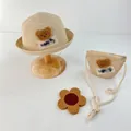 Detail of baby straw sun hat with cute brown plush bear patch and matching crossbody bag - Hat And Bag Set / Beige