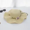 Nahaufnahme eines khakifarbenen Strohhuts mit Wellenrand und floraler Dekoration - M Erwachsene (56-58cm) / Seidennetzblume Lettuce-Kante - Beige