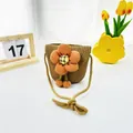 Nahaufnahme einer Strohtasche für Kinder mit auffälliger oranger Sonnenblumen-Verzierung - Orange Rosa Doppelball Blume / Khaki