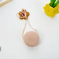 Close-up of a handmade circular straw woven shoulder bag with intricate spiral patterns - Round Bag (12x6.5cm) / Pink