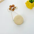 Detail of round straw crossbody bag with wood flower charm and secure silver zipper - Round Bag (12x6.5cm) / Beige