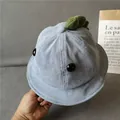 Close-up of light blue corduroy baby bucket hat with green plush dinosaur spikes - Haze Blue
