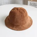 Close-up of brown corduroy bucket hat showing fine ribbed texture and metal ventilation eyelets - Brown